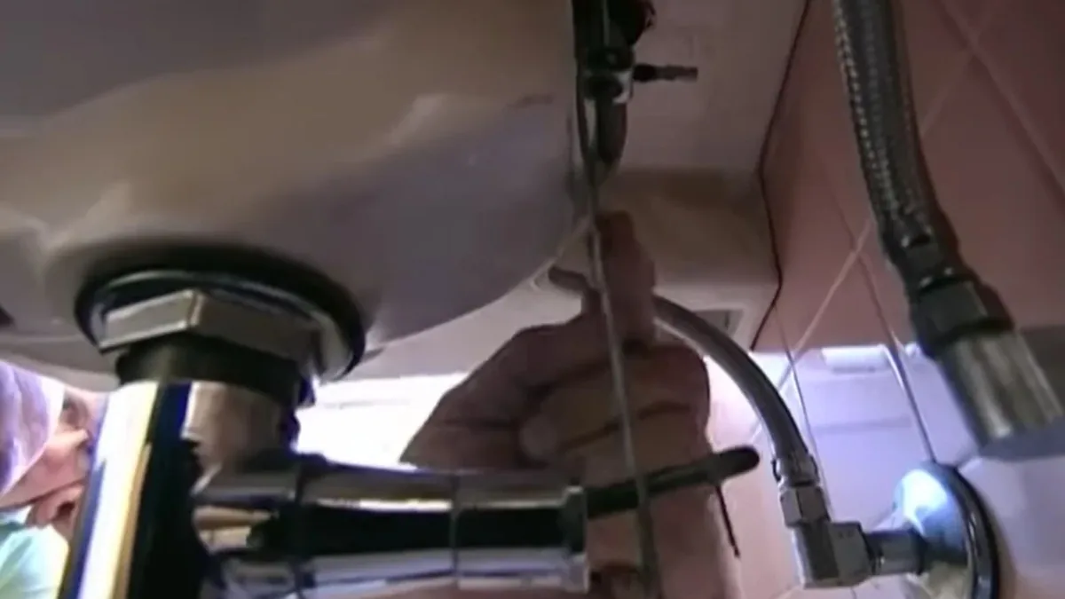Plumbing technician diagnosing a water heater in a Sun City, AZ home